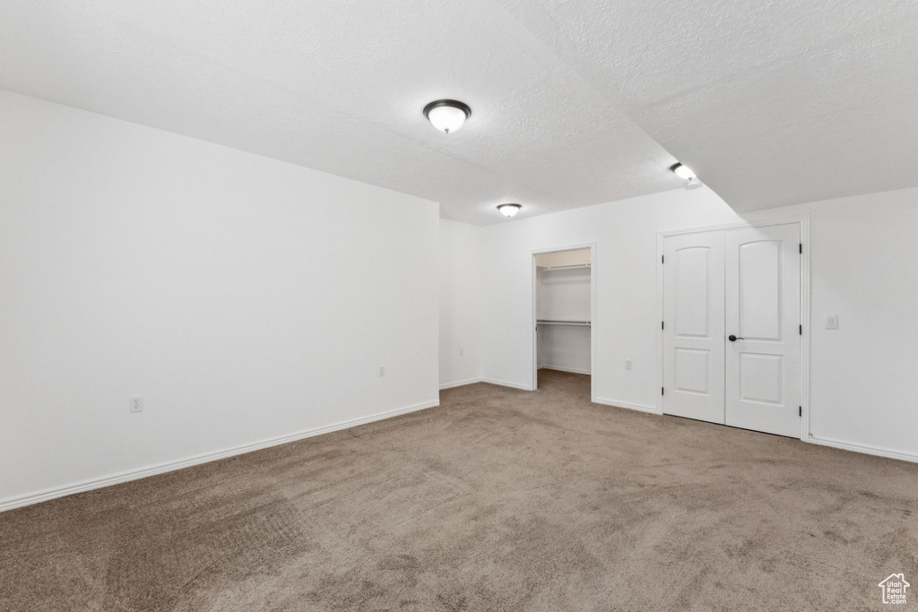 Unfurnished bedroom featuring carpet floors and a textured ceiling