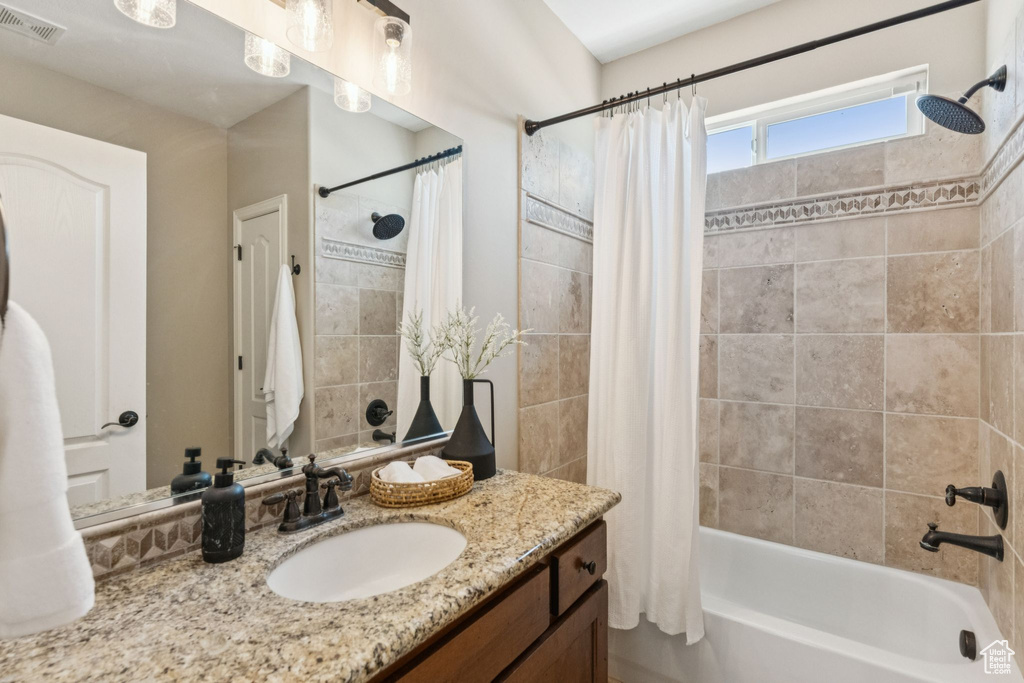 Full bath featuring vanity and shower / bath combo with shower curtain