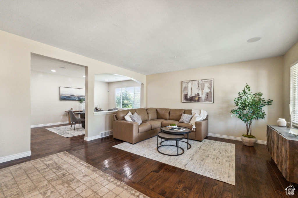 Living room featuring arched walkways, hardwood / wood-style flooring, and recessed lighting