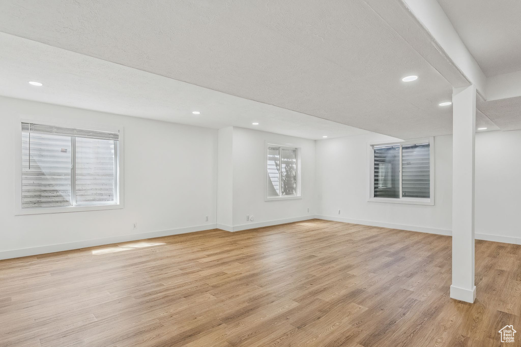 Basement with light wood-type flooring and recessed lighting