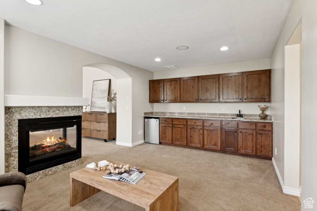 Kitchen with dishwashing machine, light carpet, light countertops, recessed lighting, and arched walkways