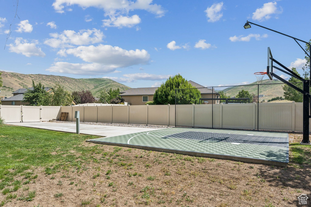 View of basketball court featuring community basketball court, a mountain view, and a gate