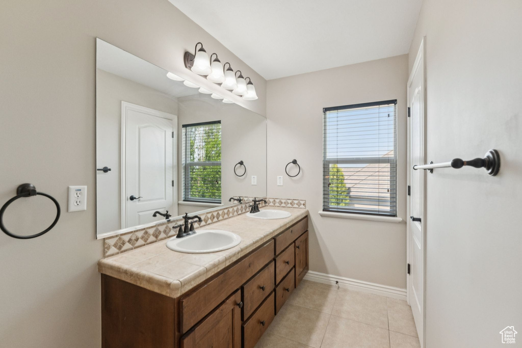 Full bath featuring double vanity and tile patterned flooring