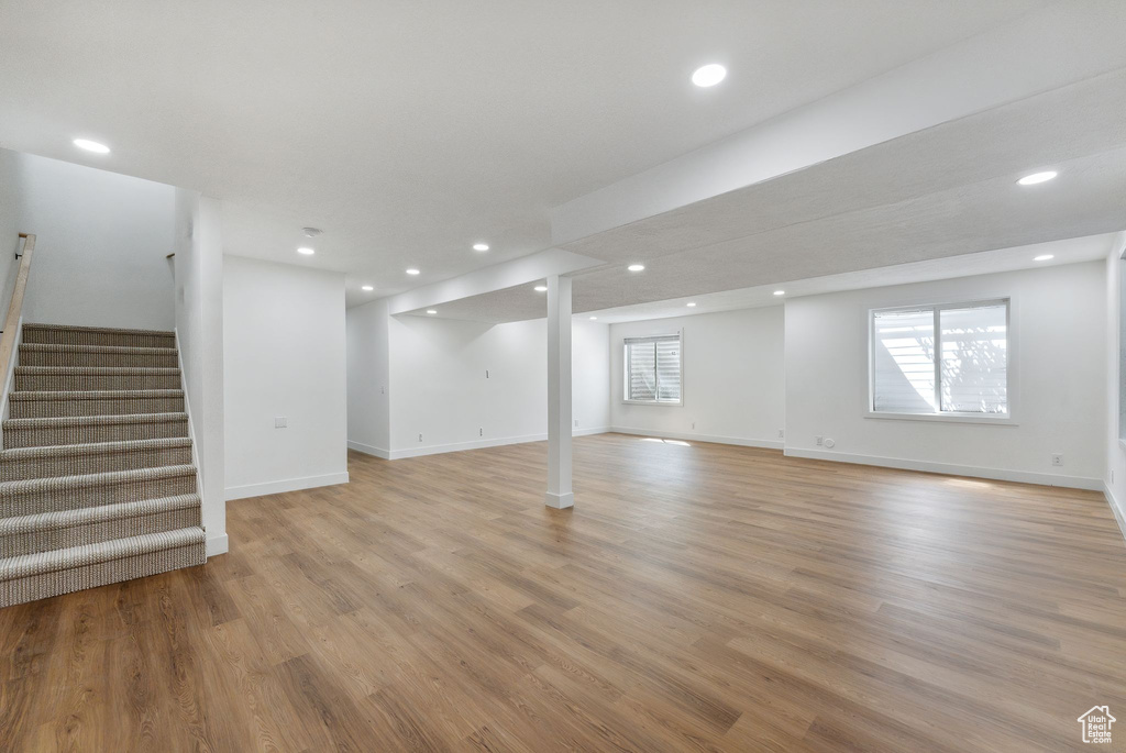 Basement with stairs, light wood finished floors, and recessed lighting
