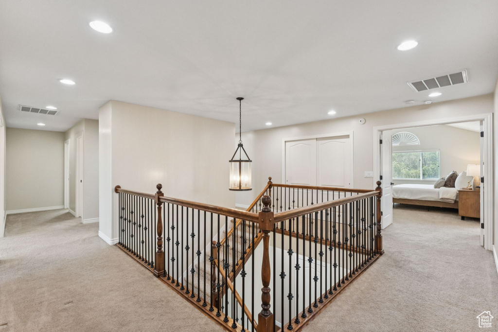 Corridor with carpet, recessed lighting, and an upstairs landing
