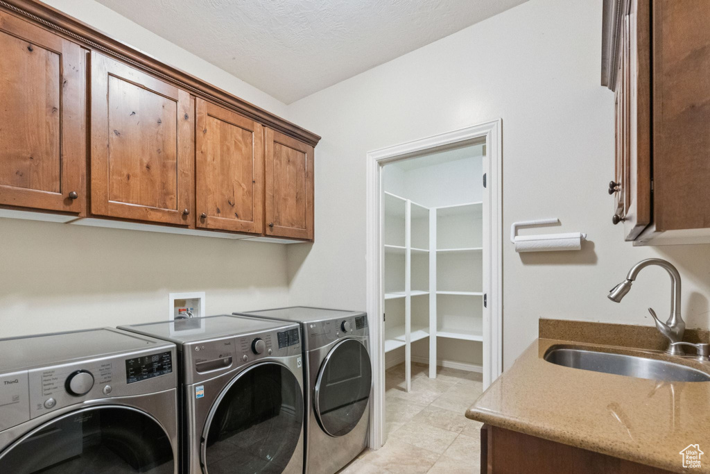 Laundry area with washer and clothes dryer and cabinet space