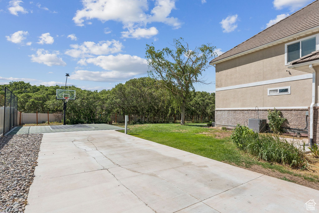 View of patio featuring driveway and basketball court