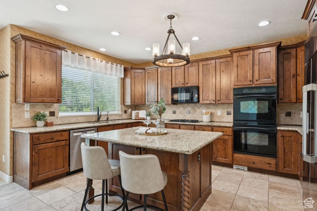 Kitchen with black appliances, a kitchen island, backsplash, recessed lighting, and brown cabinets