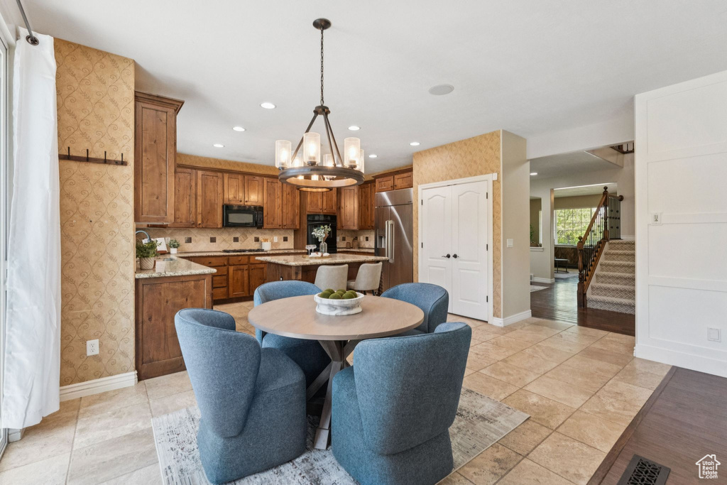 Dining area with stairs, a chandelier, recessed lighting, and wallpapered walls