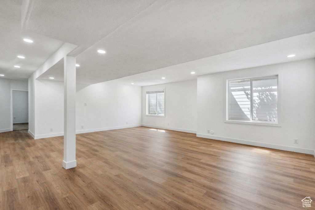 Below grade area with light wood finished floors and recessed lighting