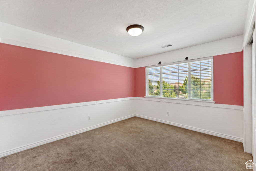 Empty room featuring carpet and baseboards