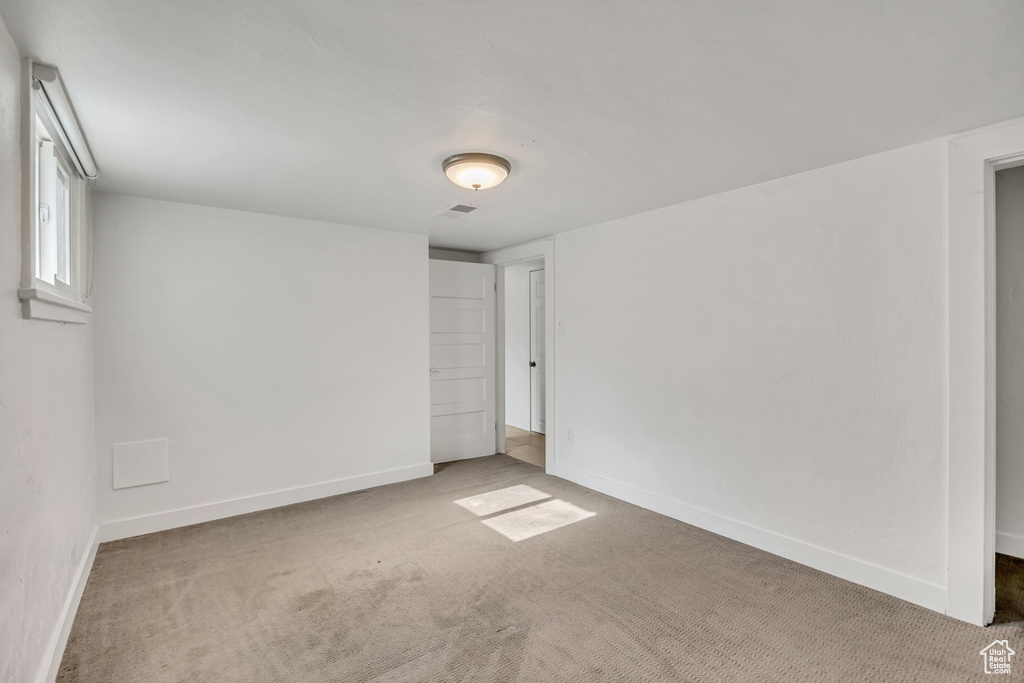 Carpeted spare room with baseboards