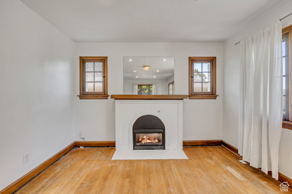 Unfurnished living room with hardwood / wood-style flooring, a fireplace, and recessed lighting
