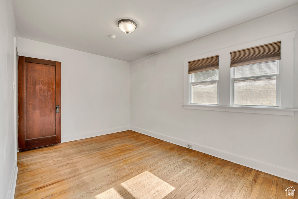 Spare room featuring light wood finished floors and baseboards