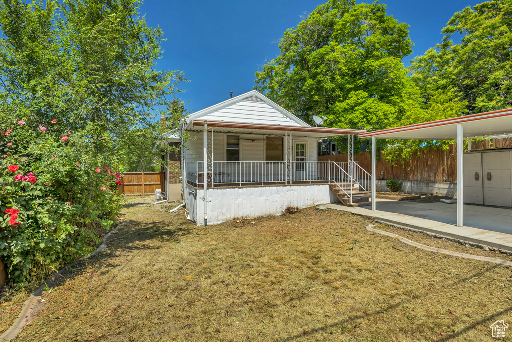 View of front of property with a fenced backyard and covered porch