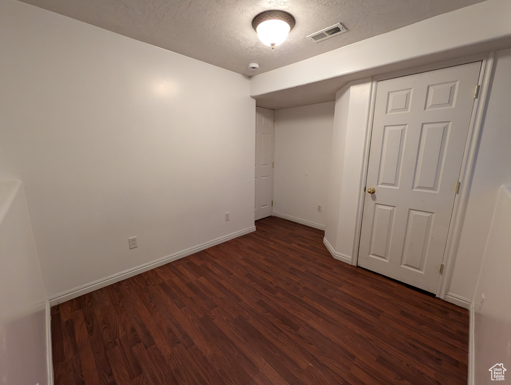 Unfurnished bedroom with wood finished floors and a textured ceiling