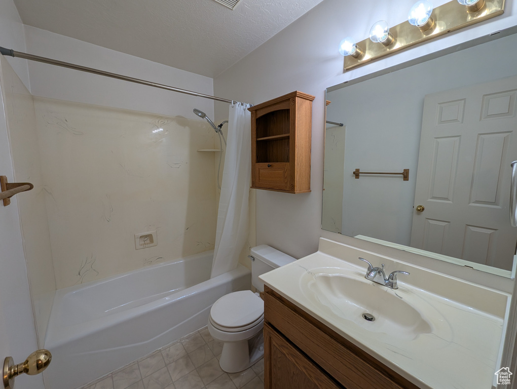 Bathroom with shower / tub combo, vanity, tile patterned floors, and a textured ceiling