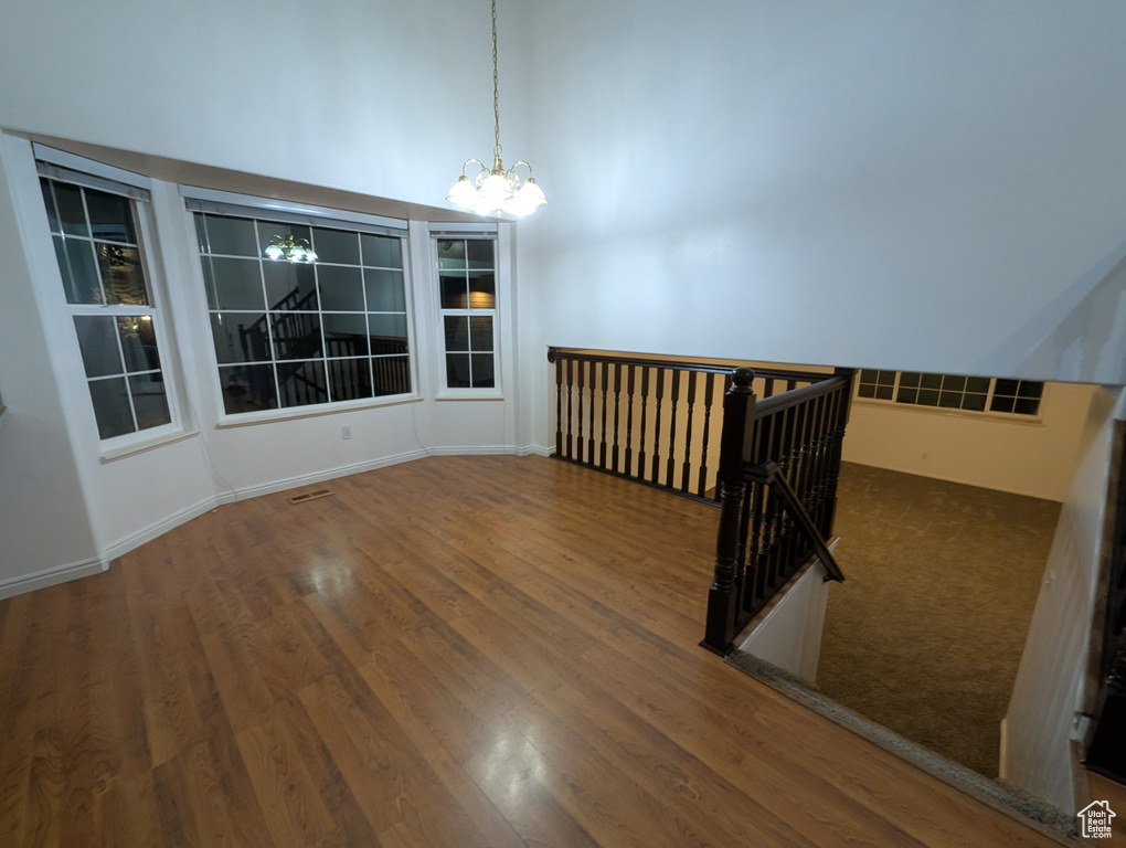 Unfurnished room featuring a chandelier and wood finished floors
