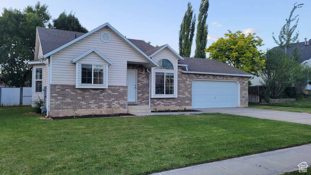 Ranch-style home featuring driveway, an attached garage, brick siding, and roof with shingles