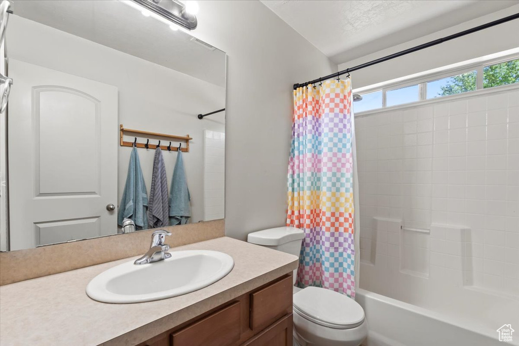 Full bath featuring vanity and shower / bathtub combination with curtain