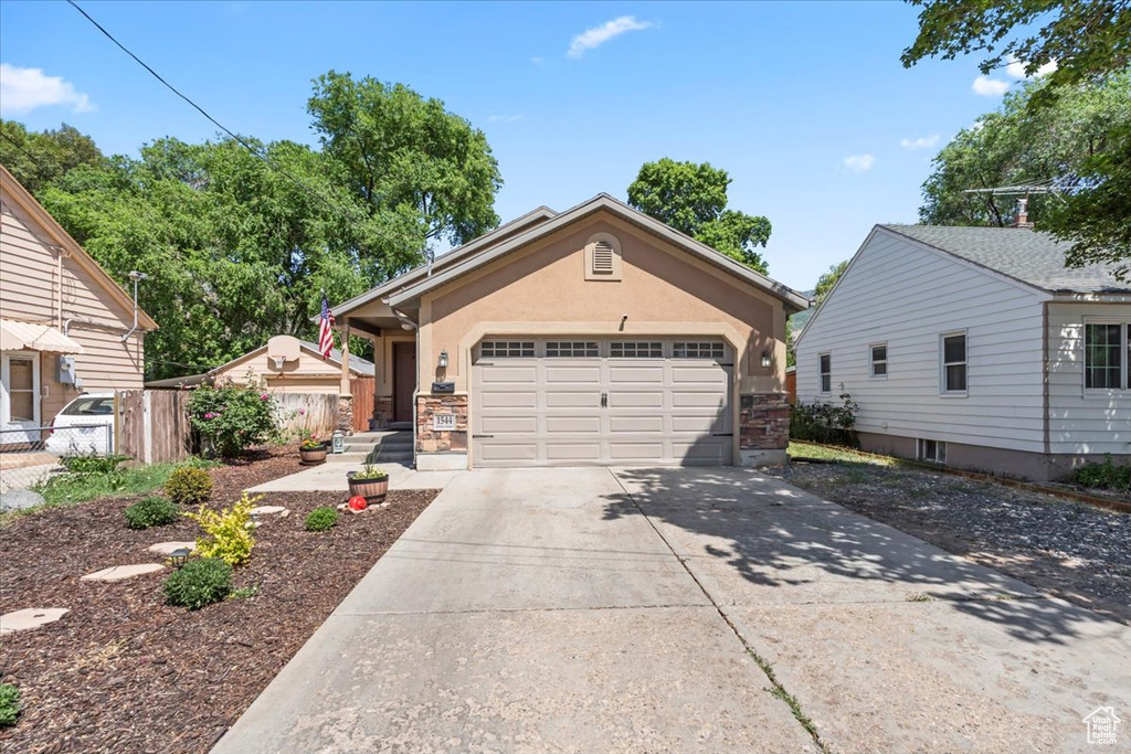View of front facade with concrete driveway, a garage, and stucco siding