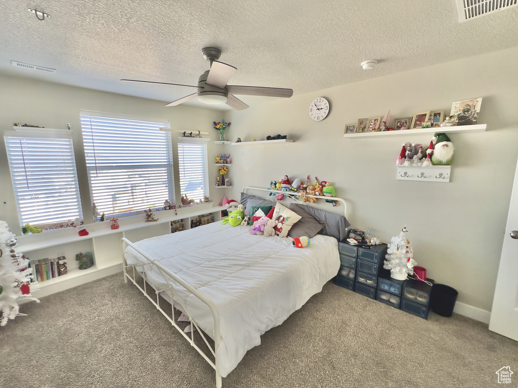 Bedroom with carpet, a textured ceiling, and ceiling fan