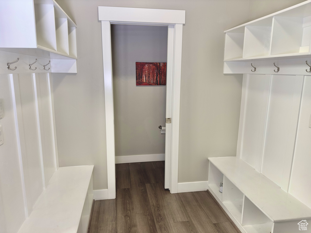 Mudroom featuring dark wood-style flooring and baseboards