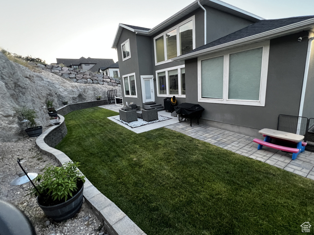 Rear view of property featuring stucco siding, a patio area, outdoor lounge area, and entry steps