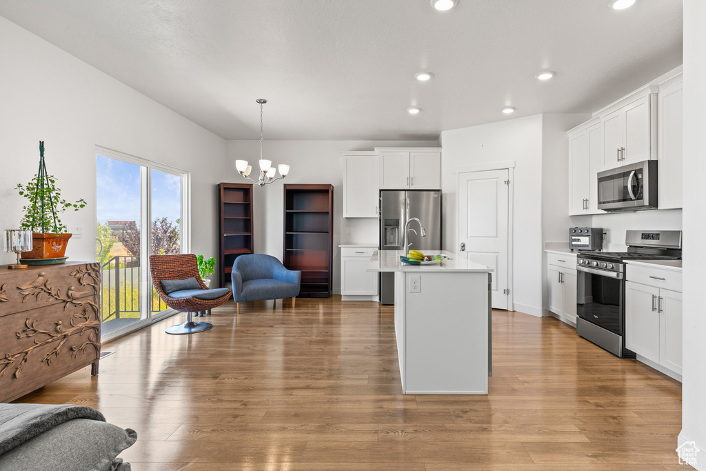 Kitchen featuring stainless steel appliances, recessed lighting, a chandelier, light wood-style floors, and light countertops