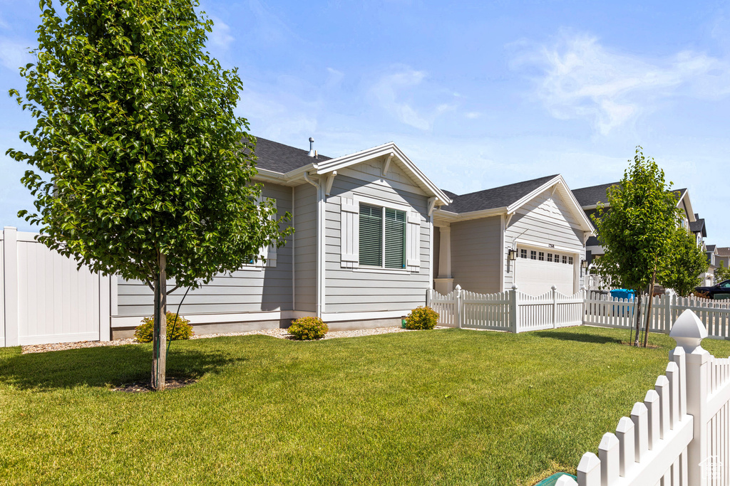 Single story home with an attached garage and a shingled roof