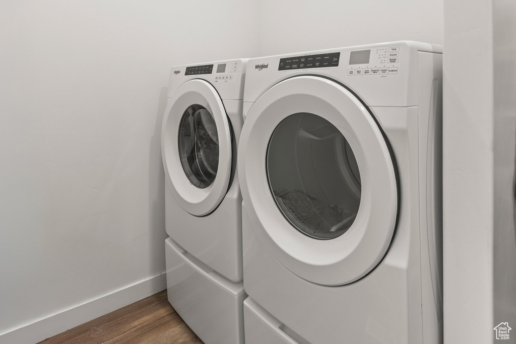 Laundry area featuring separate washer and dryer and wood finished floors