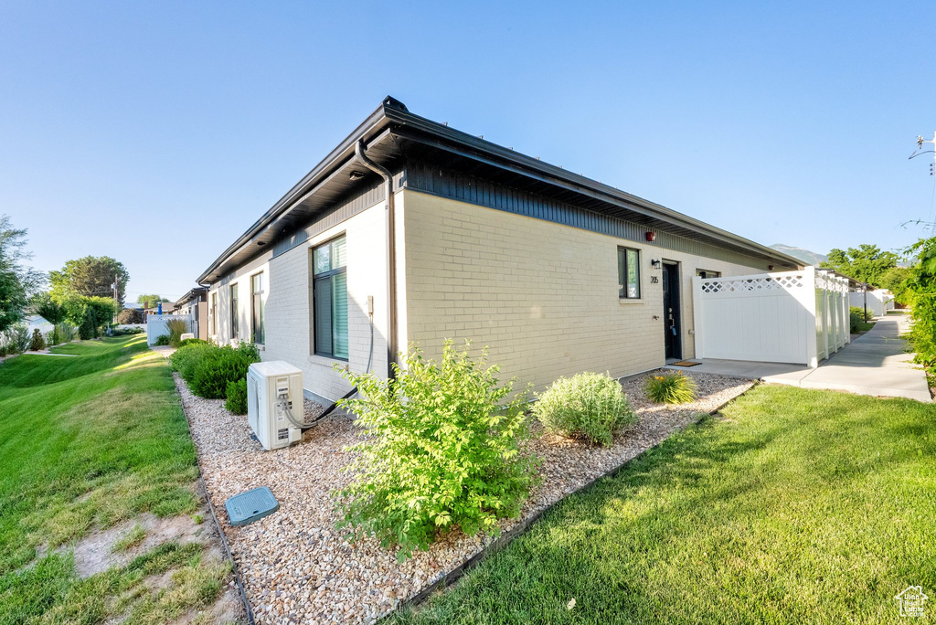 View of property exterior with brick siding and an ac unit