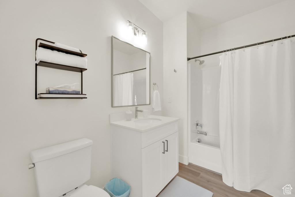 Bathroom with vanity, wood finished floors, and shower / bath combo