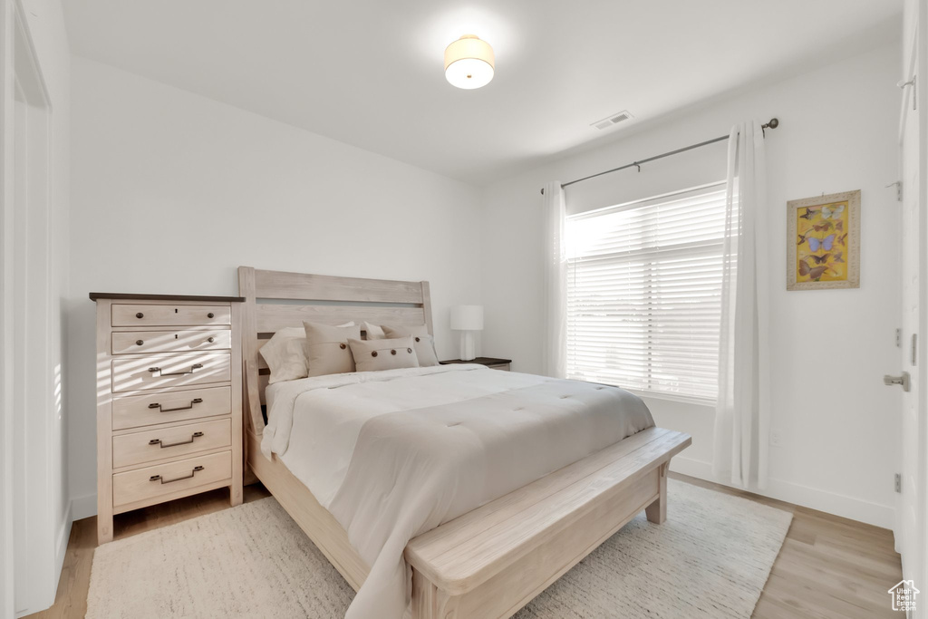 Bedroom with light wood finished floors and baseboards