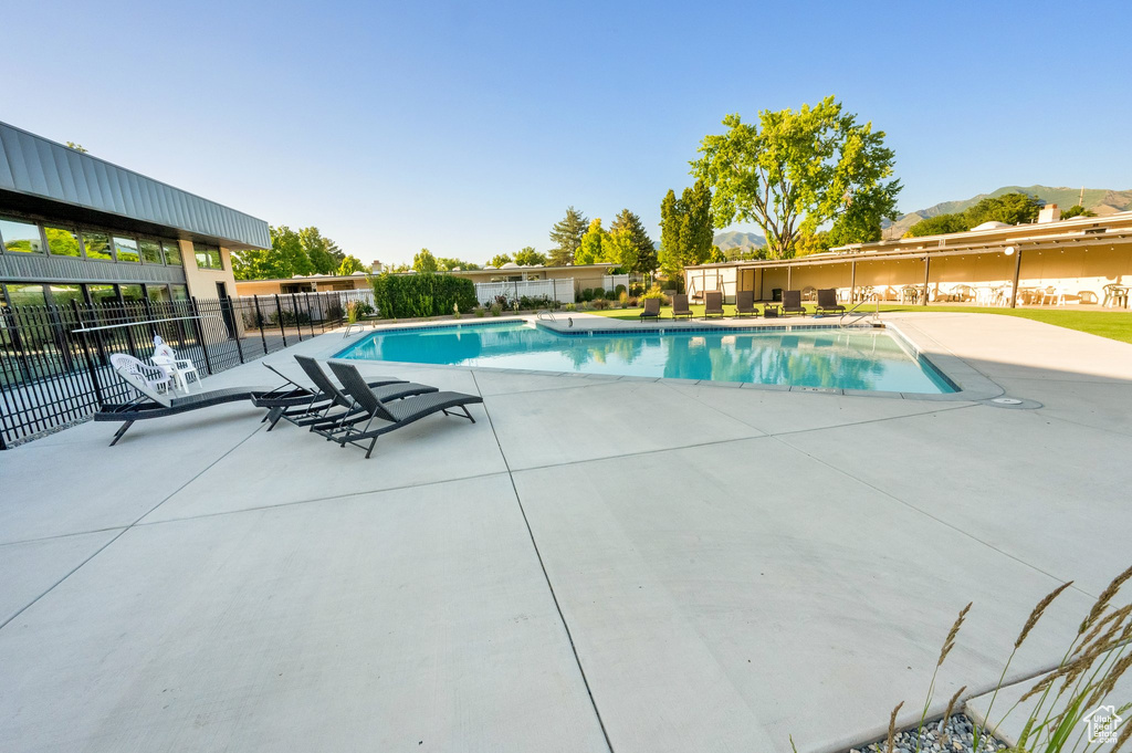Community pool with a patio area and a mountain view