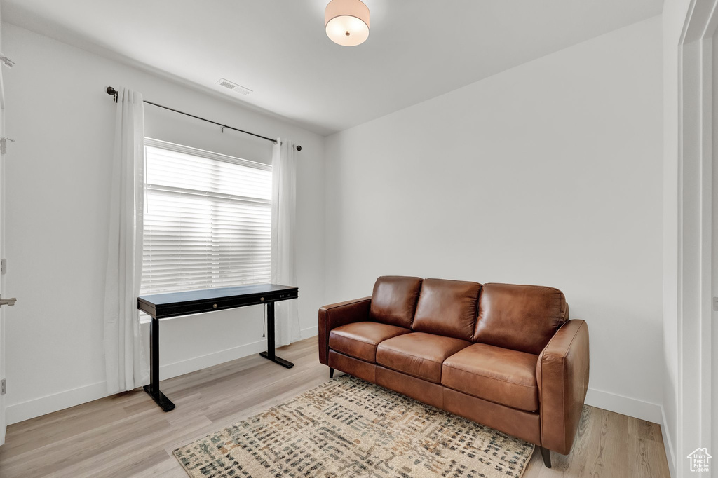 Living area with light wood finished floors and baseboards