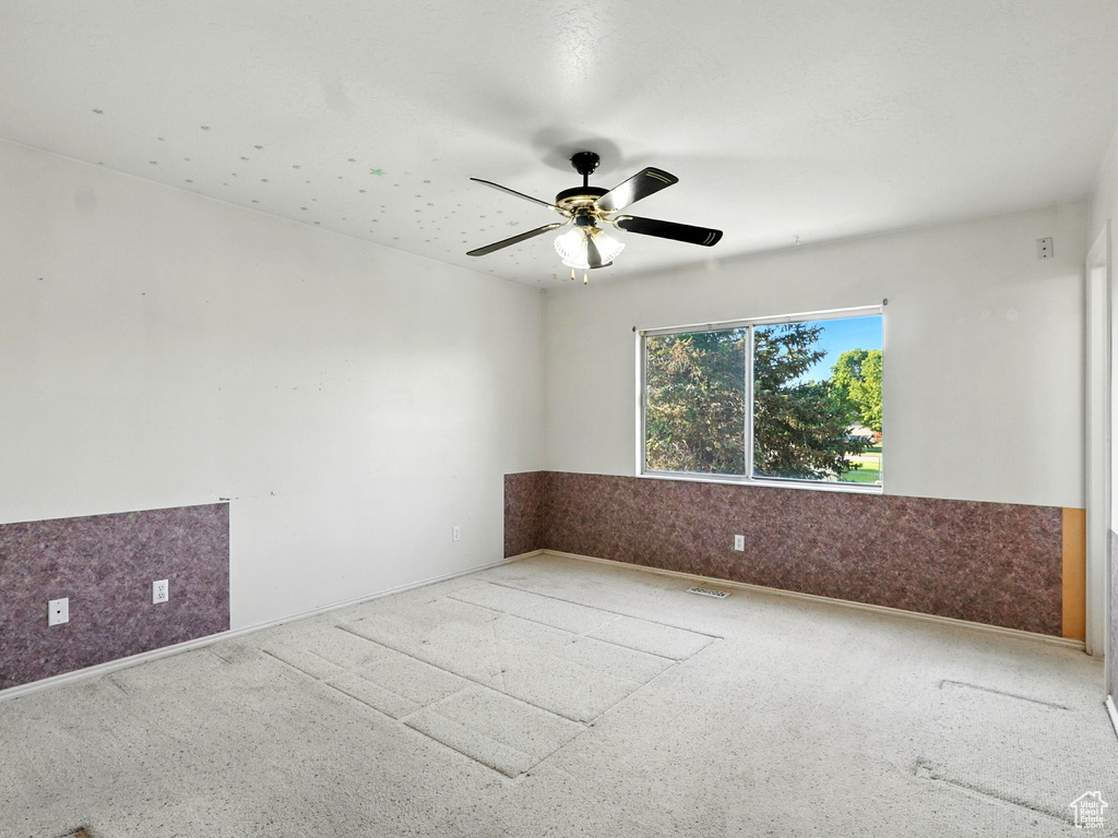 Unfurnished room with wainscoting and ceiling fan