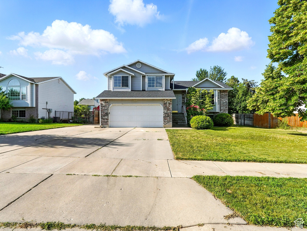 View of front facade with concrete driveway, an attached garage, and brick siding