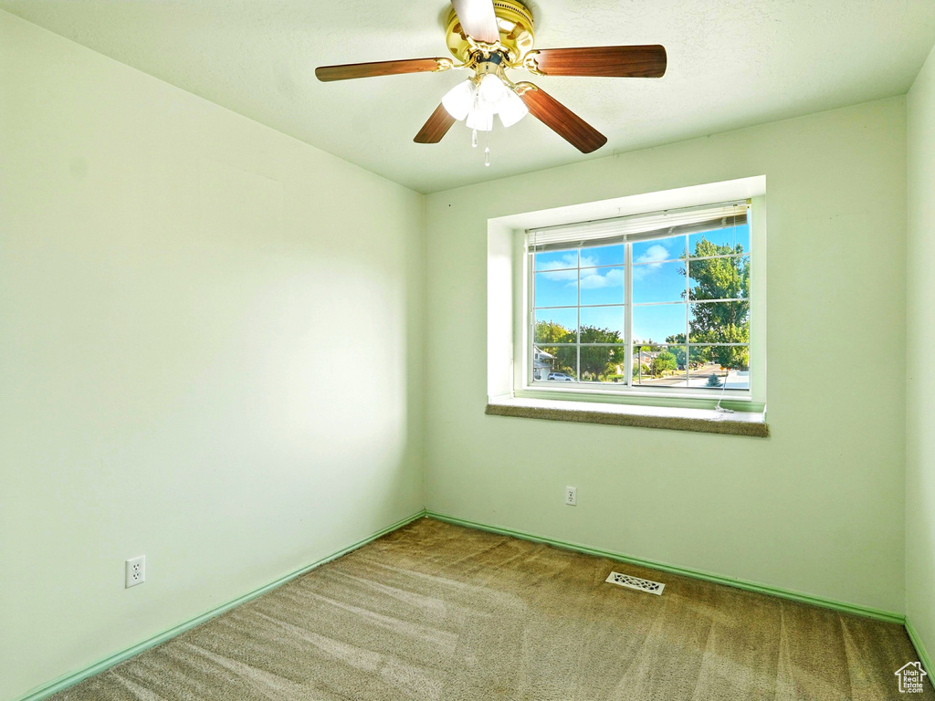 Unfurnished room with carpet flooring and a ceiling fan
