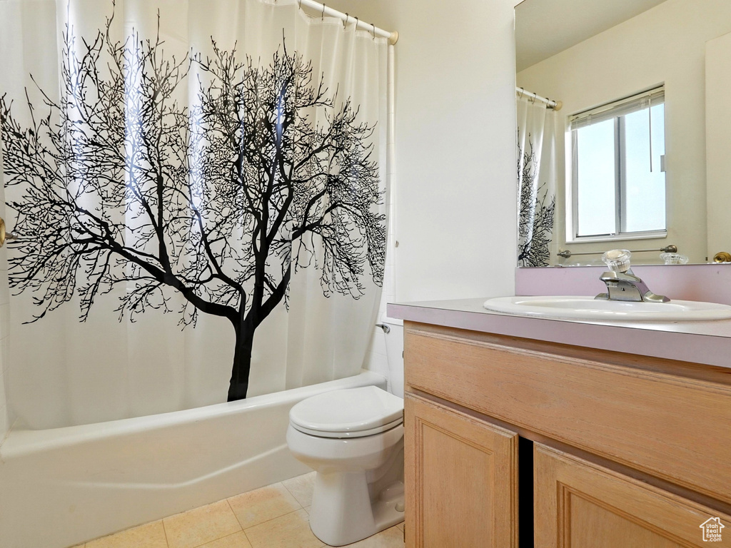 Bathroom with vanity, tile patterned floors, and shower / tub combo
