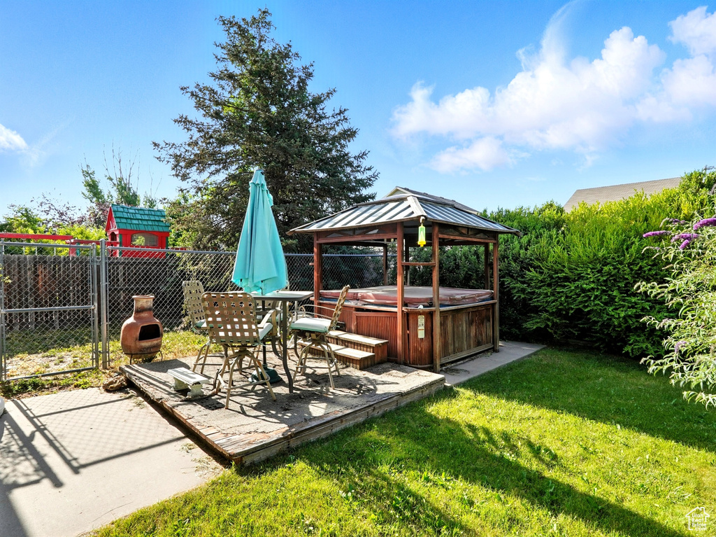 View of yard with a hot tub, a gazebo, and a patio