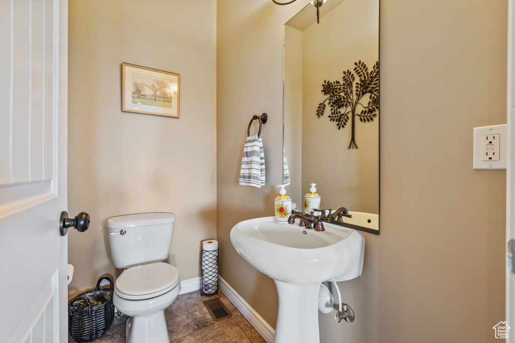 Half bathroom with toilet and baseboards