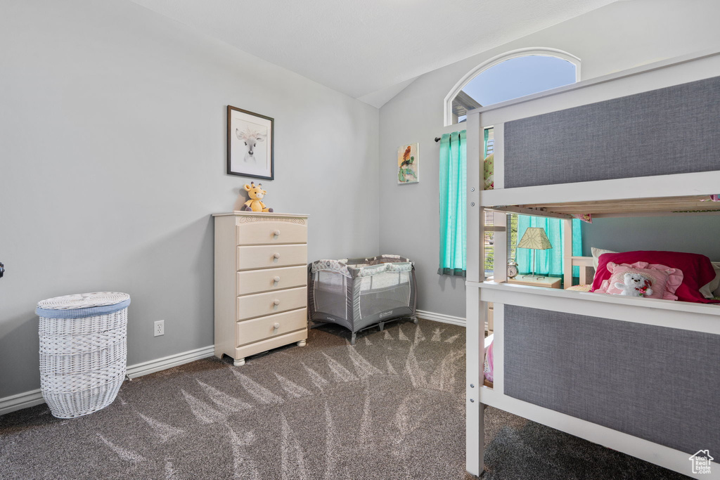 Bedroom with lofted ceiling and carpet floors