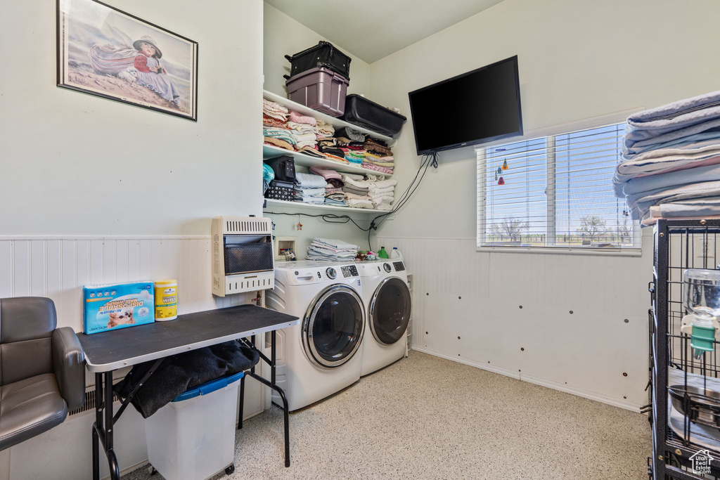 Washroom with washing machine and dryer, heating unit, and a wainscoted wall