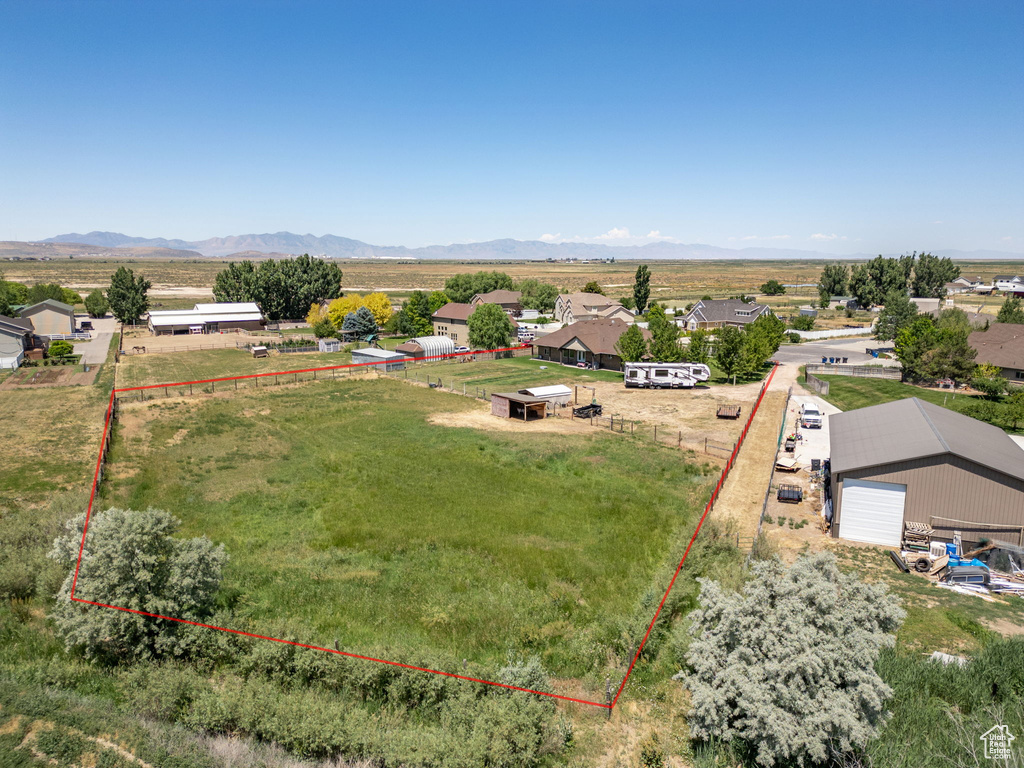 Aerial view of sparsely populated area featuring property parcel outlined and a mountainous background