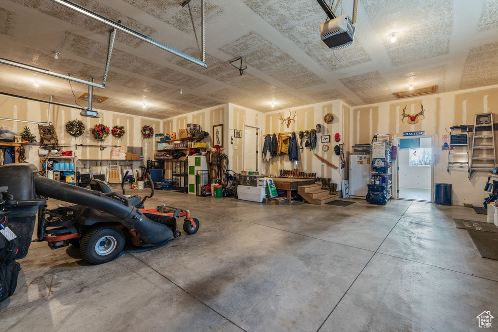 Garage with a garage door opener and a workshop area