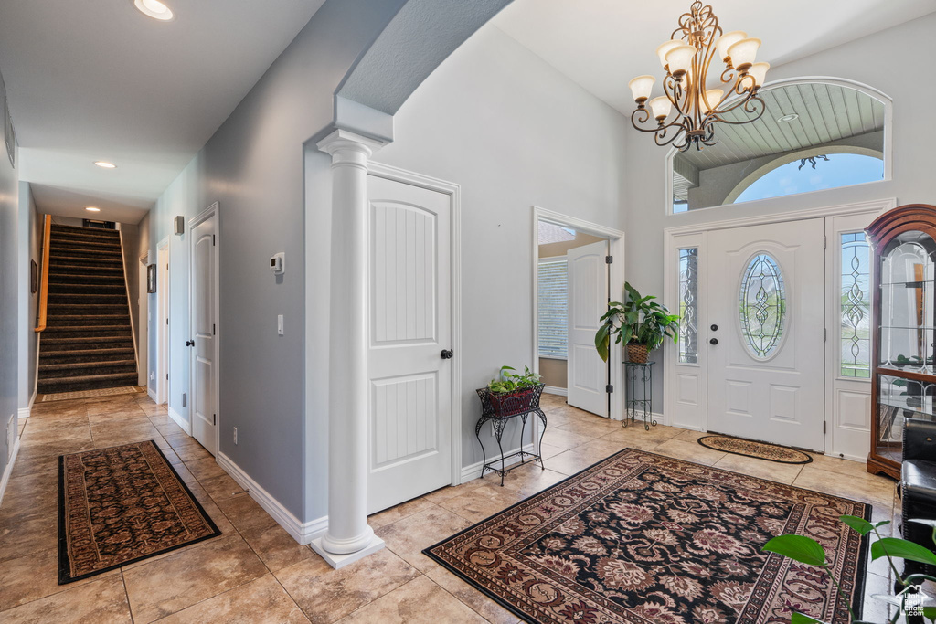 Foyer entrance with stairs, decorative columns, a chandelier, recessed lighting, and light tile patterned floors
