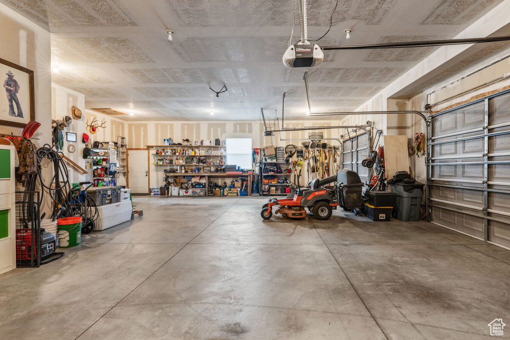 Garage featuring a garage door opener and a workshop area