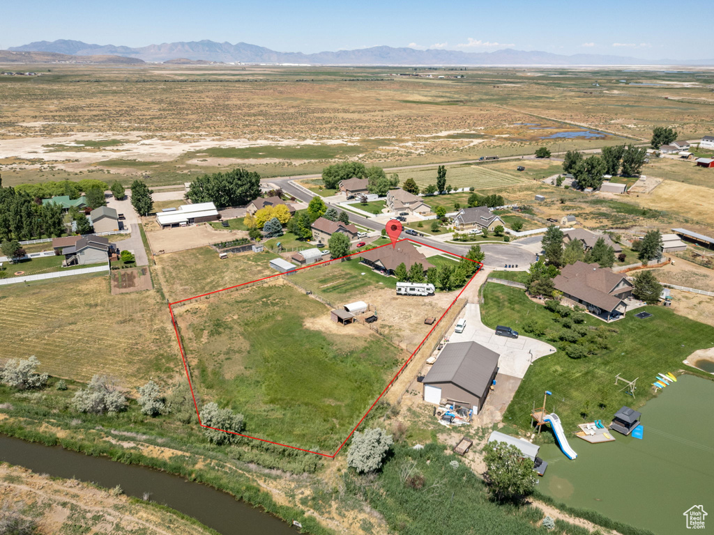 Overview of rural landscape with property parcel outlined and a mountainous background
