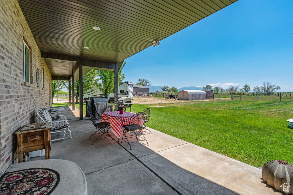 View of patio featuring a storage unit